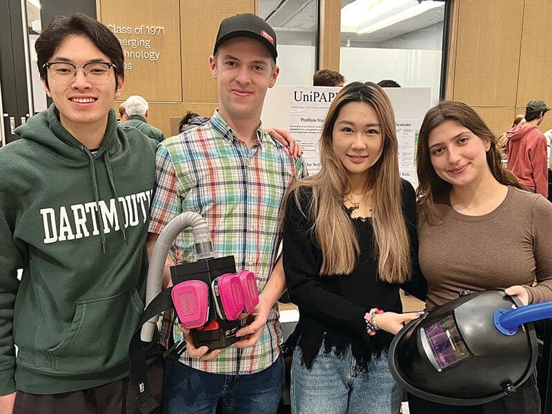 Students hold welding helmet they innovated for ENGS 21 course.