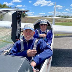 Jim Becker and co-pilots smiles at camera on a plane.