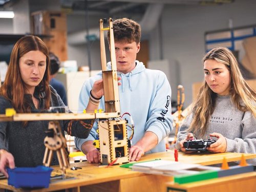 BE students (from left) Abbey Clut- terbuck ’26, Matthew McPherson ’26, and Isabella Casaretto ’26 test their joystick- controlled design for ENGS 76: “Machine Engineering.” The new initiative will sup- port future fifth-year students pursuing BE degrees.