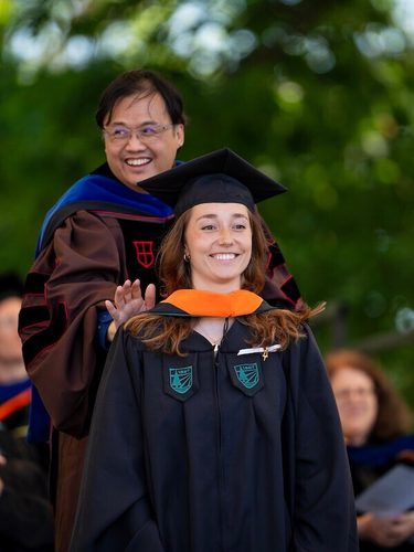 Professor Eugene Santos and a student at the hooding ceremony smiling