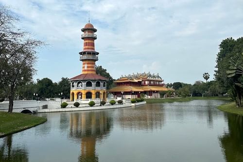A building with a tower by a lake in Thailand.