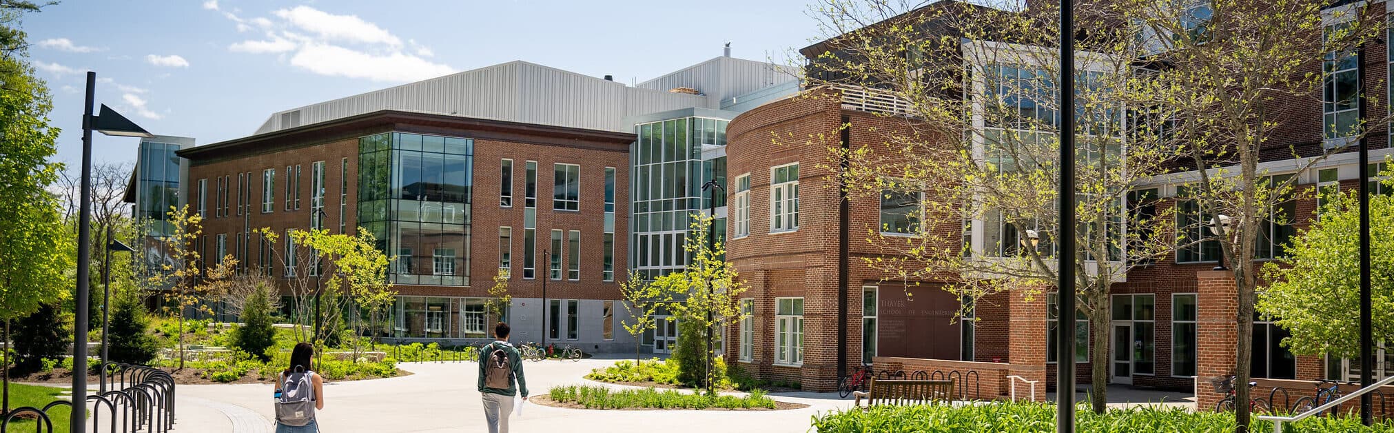 Two students walk towards the new Class of 1982 building on a sunny day.