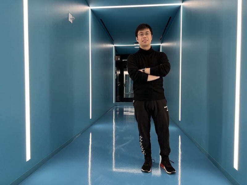 Yihuang Xiong stands in a lit hallway
