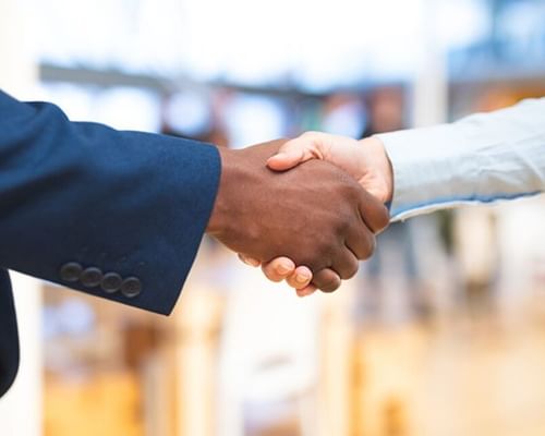 Two people shake hands at a career fair.