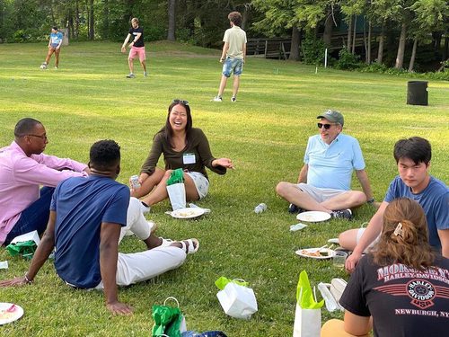group of people enjoying a picnic on green grass in the summer