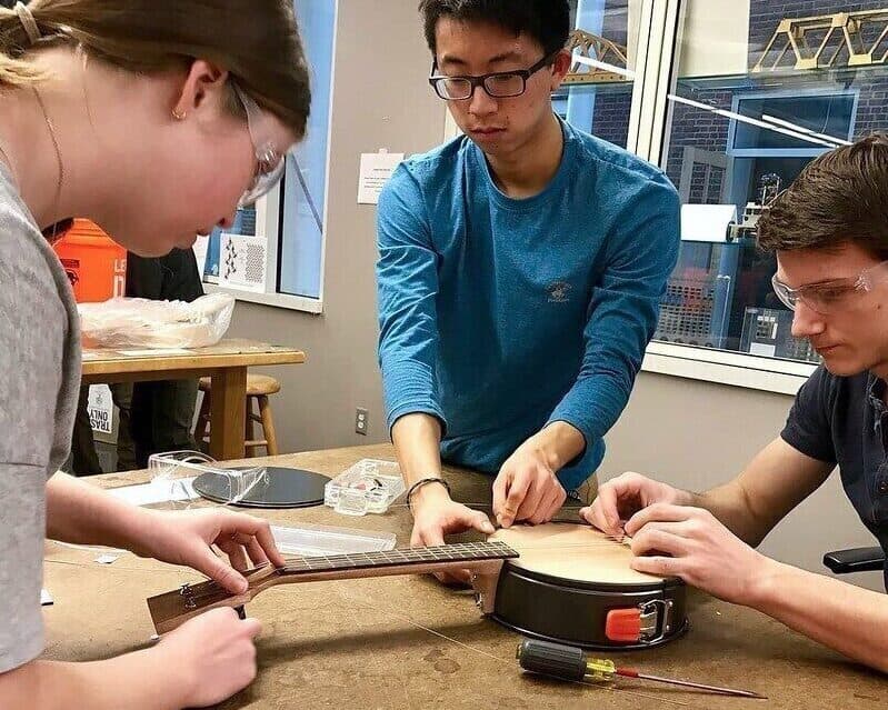 Three students make banjo in